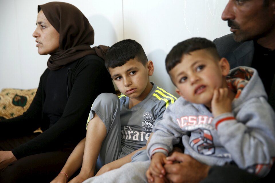 Freed Yazidi boy Murad (C), 9, who was trained by Islamic State, sits next to his five-year-old brother Emad and his parents at their home in a refugee camp near the northern Iraqi city of Duhok.  (Reuters Photo/Ahmed Jadallah)