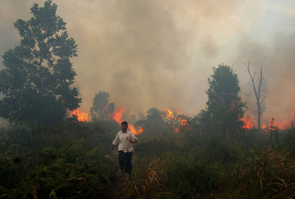 A student of Islamic boarding school Nurussalam in East Dumai, Riau, runs away from a forest fire, Monday (04/04).  (Antara Photo/Aswaddy Hamid)