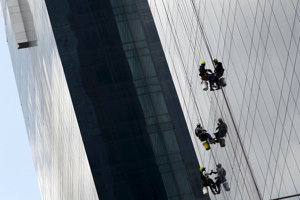 Workers clean windows of a building at the banking area of Panama City, April 4, 2016. (Reuters Photo/Carlos Jasso)