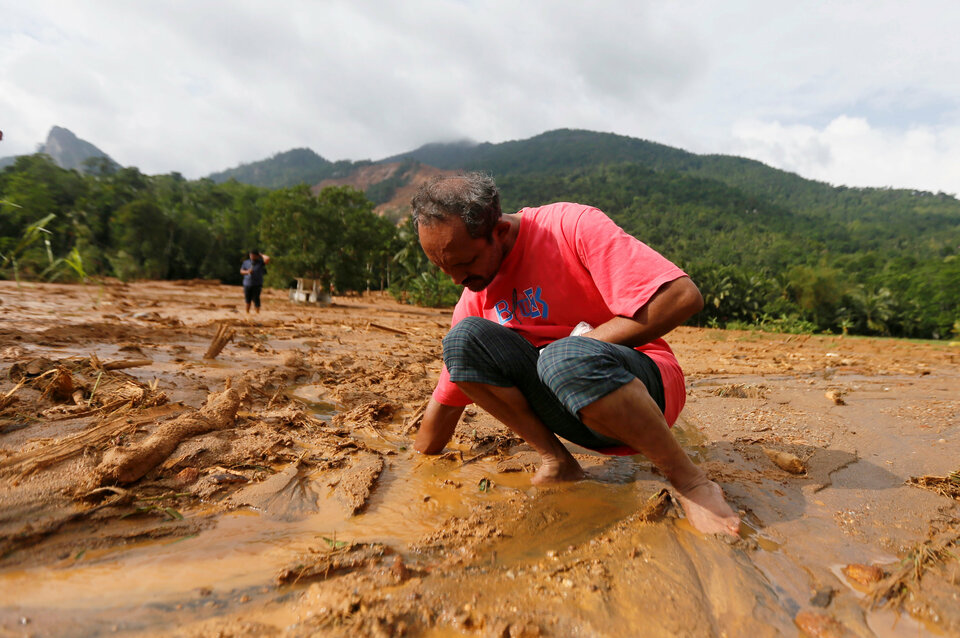 A man tries to find his slippers under mud after a landslide at Elangipitiya village in Aranayaka , Sri Lanka May 19, 2016. (Reuters Photo/Dinuka Liyanawatte)