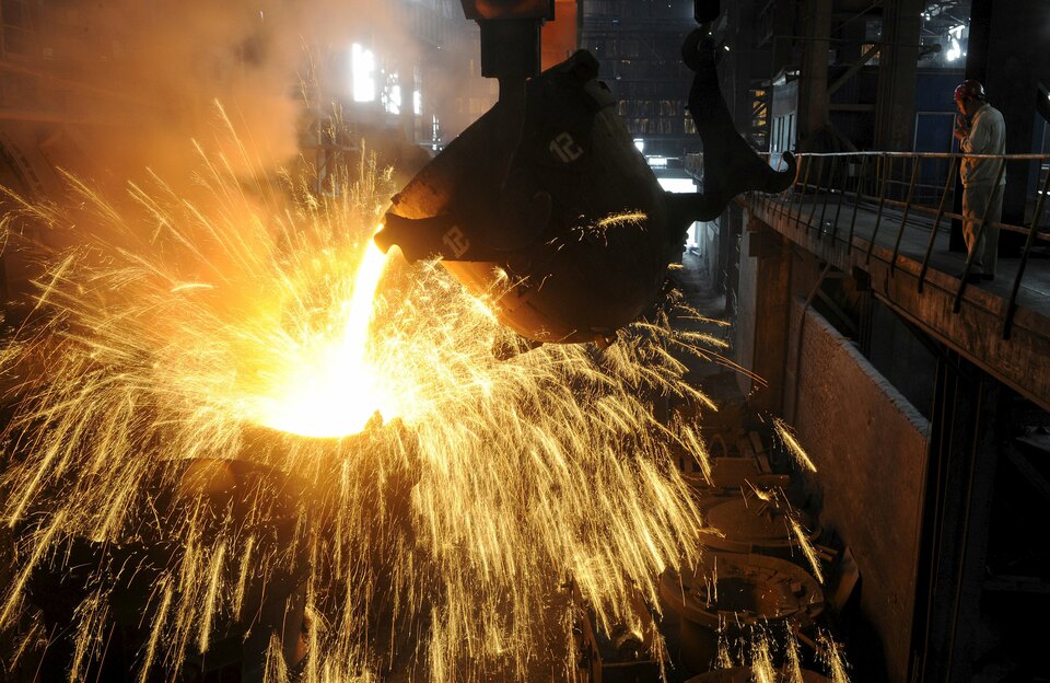 An employee monitors molten iron being poured into a container at a steel plant in Hefei, Anhui province. (Reuters Photo/Stringer) 