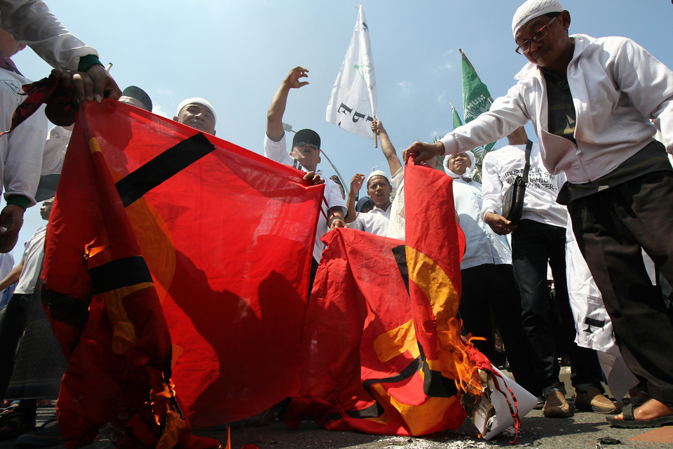 Members of the Islamic Defenders Front (FPI) and Pancasila Front Group burn flags they claim to be symbols of the Indonesian Communist Party in April 2016. (Antara Photo/Didik Suhartono)