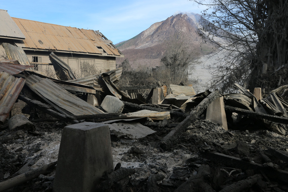 A house destroyed by hot clouds is now buried under volcanic ash after Mount Sinabung in North Sumatra unleashed a series of eruptions on Saturday (21/05). (Antara Photo/Irsan Mulyadi)