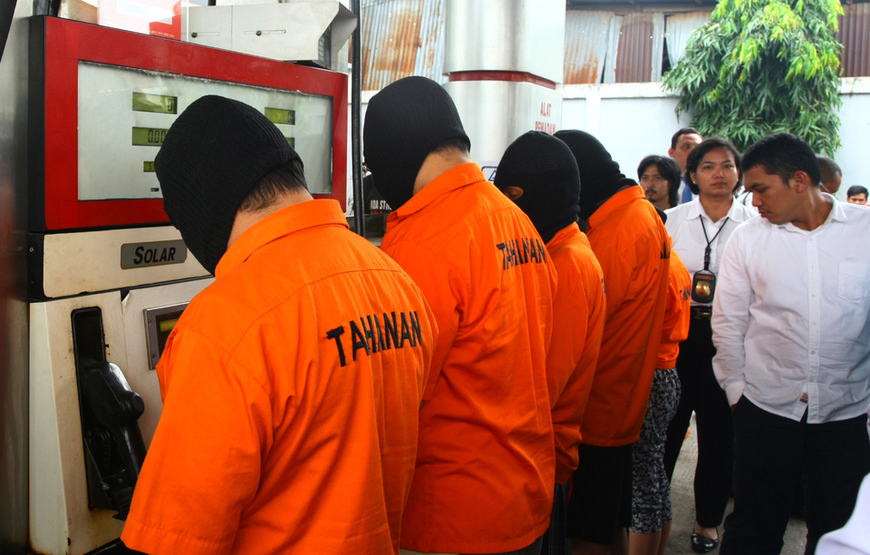 Five people accused of stealing fuel from gas stations using a modified remote control are paraded by the police at a gas station in Rempoa. (Antara Photo/Muhammad Iqbal)