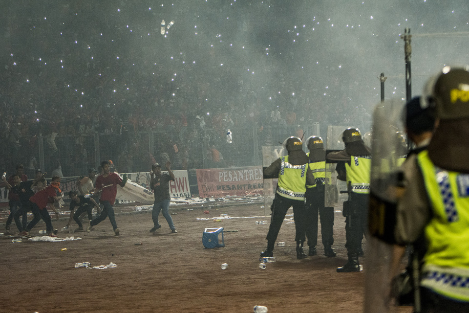 Police officers confront Persija supporters, known as Jakmania, during the riot that broke out at the Torabika Soccer Championship match between the local side and Sriwijaya at the Gelora Bung Karno Stadium in Senayan, South Jakarta, on Friday night (24/06). (Antara Photo/Aprillio Akbar)