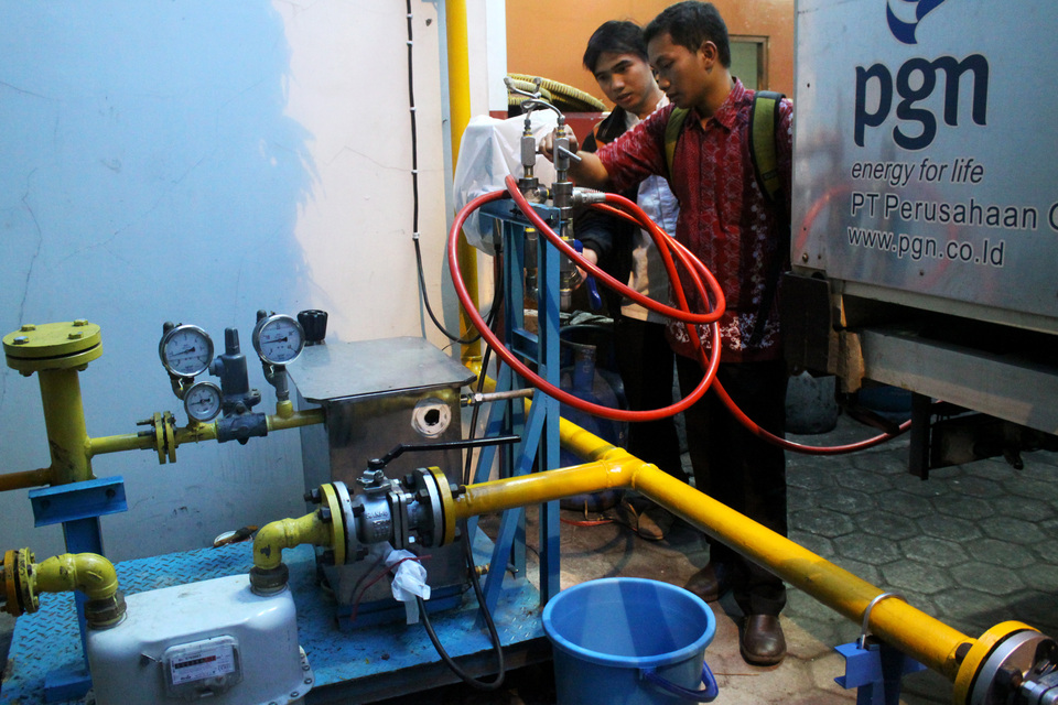 Workers of state-controlled gas distributor Perusahaan Gas Negara (PGN) check a pressure reducing system at a restaurant in Rawamangun, East Jakarta, on Friday (17/06). PGN, through its subsidiary Gagas Energi Indonesia, has started to pipe compressed natural gas to commercial clients for the first time. The installation has a capacity of 6,000 cubic meters of gas per month. (Antara Photo/Risky Andrianto)
