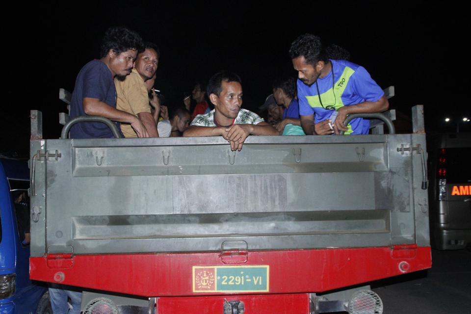 Indonesian workers catch a ride on an Indonesian Army truck on the Malaysia-Indonesia border in Nunukan, North Kalimantan after they were deported from Malaysia. (Antara Photo/M. Rusman)