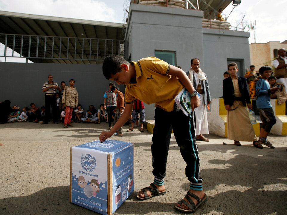 A boy puts money inside a box as a contribution for the United Nations during a demonstration against the removal of the Saudi-led coalition from the United Nations annual child rights blacklist, outside the United Nations offices in Sanaa, Yemen, June 15, 2016. (Reuters Photo/Khaled Abdullah)