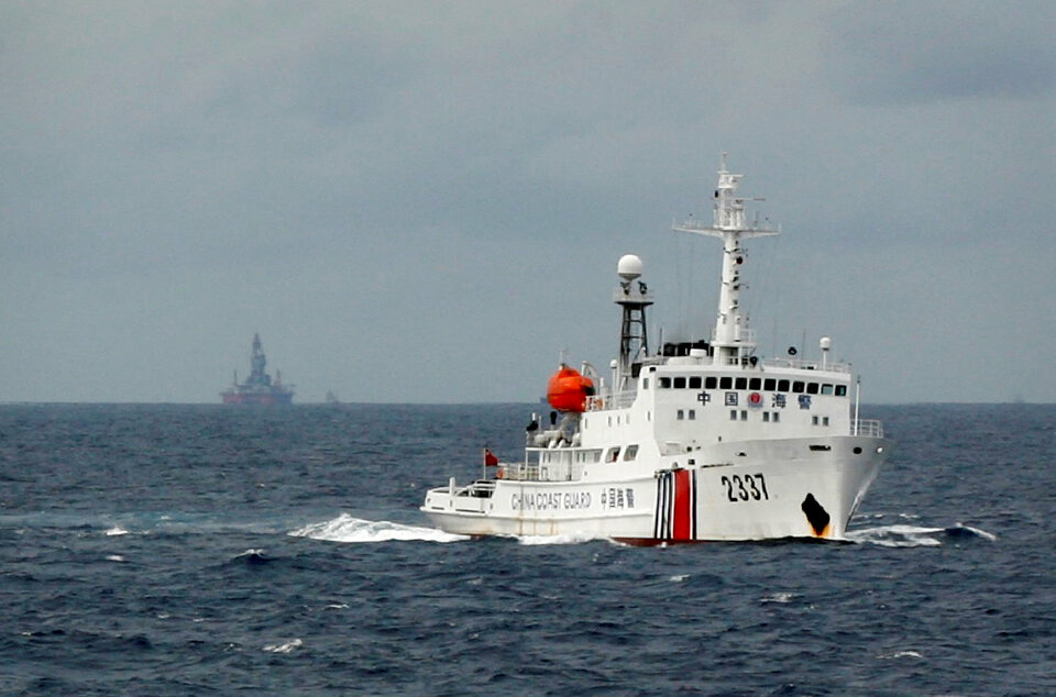 A Chinese Coast Guard vessel passes near a Chinese oil rig in the South China Sea. (Reuters Photo/Nguyen Minh)