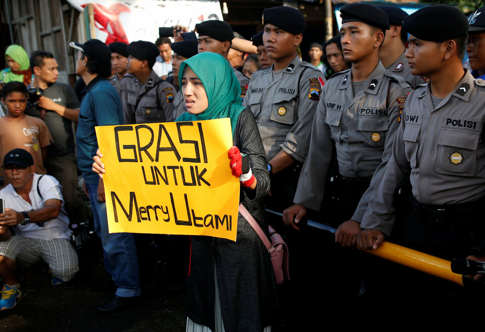 A woman holds a placard which reads "Clemency for Merry Utami", a death-row prisoner, near the gate to the ferry port for the prison island of Nusa Kambangan island, ahead of the expected execution of 14 drug convicts in Cilacap, Central Java, Indonesia July 28, 2016. (Reuters Photo/Darren Whiteside)