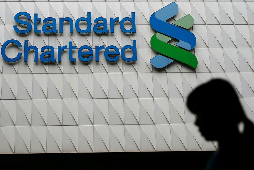 A woman walks past Standard Chartered logo at its headquarters in Hong Kong, China August 4, 2016. (Reuters Photo/Tyrone Siu)