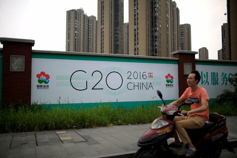 A man rides an electronic bike past a billboard for the G20 summit in Hangzhou, Zhejiang province, China, in July. (Reuters Photo/Aly Song)