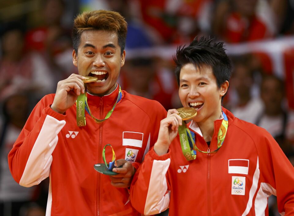 Indonesian gold medalists, Tontowi Ahmad and Liliyana Natsir, pose as if biting their medals. (Reuters Photo/Mike Blake)