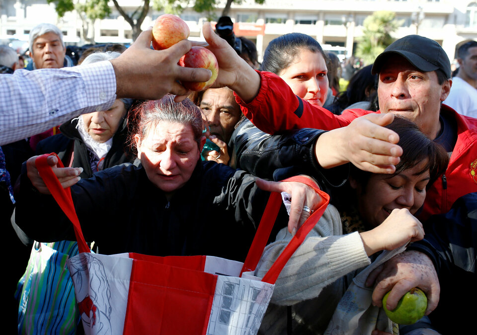 People receive free pears and apples during a protest staged by Argentine producers and farmers from the Patagonian provinces of Neuquen and Rio Negro for their losses in the activity in Buenos Aires, Argentina, August 23, 2016. (Reuters Photo/Enrique Marcarian)