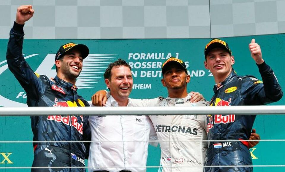 Red Bull Racing's Daniel Ricciardo, left, and Max Verstappen, right, pose with Mercedes' Lewis Hamilton after the race at Hockenheim on Sunday (31/07). (Reuters Photo/Ralph Orlowski)