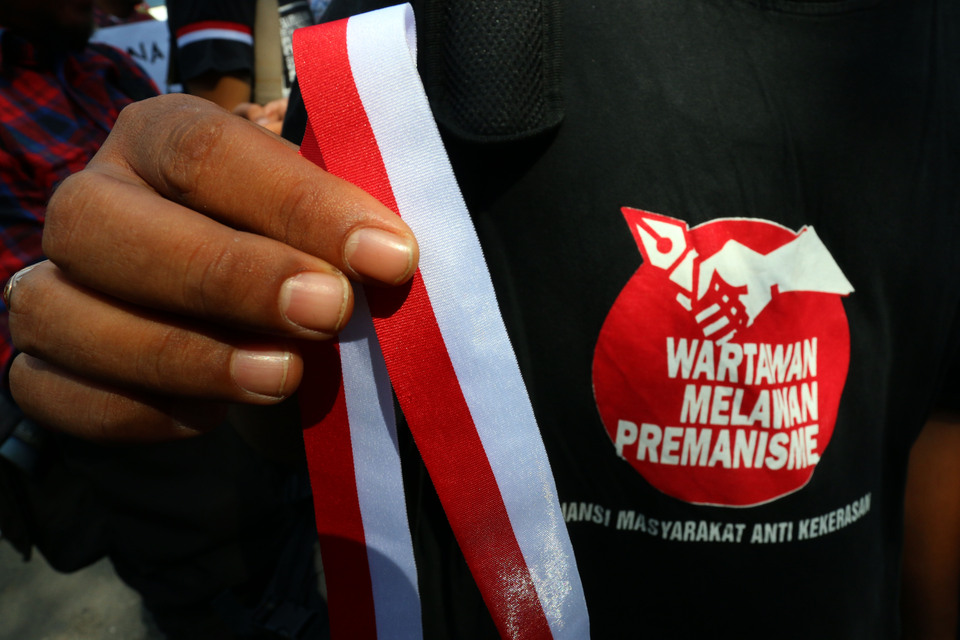 A journalist displaying an anti-violence pin during a protest at Bundaran Harapan in Medan, North Sumatra, on Tuesday (16/08) after the clashes with military personnel a day earlier. (Antara Photo/Irsan Mulyadi)