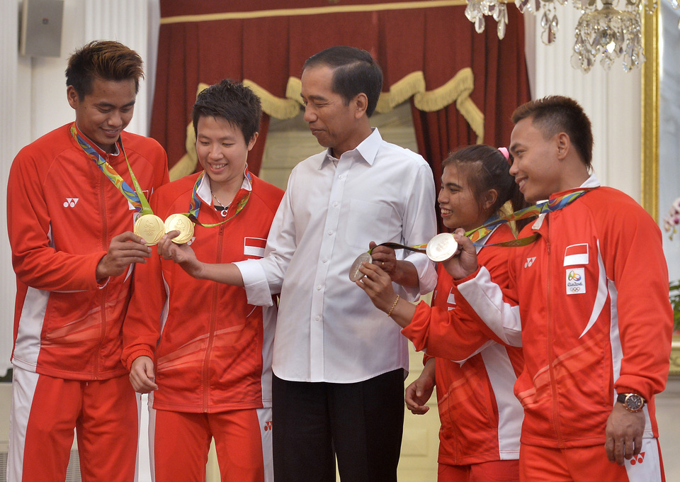 President Joko 'Jokowi' Widodo flanked by Olympic medalists, from left Tontowi Ahmad, Liliyana Natsir, Sri Wahyuni Agustiani and Eko Yuli Irawan, at the State Palace in Jakarta on Aug. 24. (Antara Photo/Yudhi Mahatma)