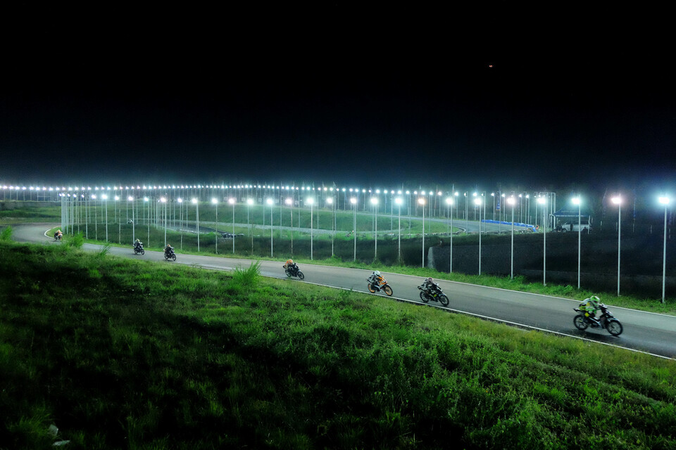 Riders race under lights during the Sidraprix Night Race in Sidenreng Rappang, South Sulawesi, on Sunday (28/08). (Antara Photo/Sahrul Manda Tikupadang)
