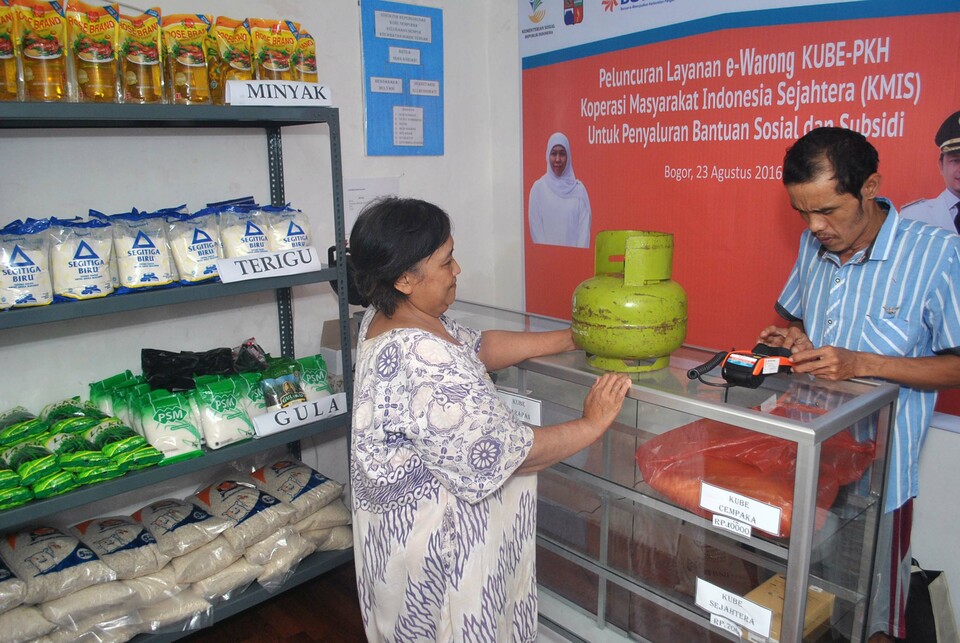 A local resident is pictured performing a cashless transaction at a designated e-warung in Lebak Kantin, Sempur village, Bogor, West Java, on Wednesday (24/08). The e-warung program is a cashless payment system set up by social aid programs such as Joint Business Group (KUBE) and Family of Hope (PKH) under the purview of the Ministry of Social Affairs, integrating food subsidy and food aid programs. (Antara Photo/Arif Firmansyah)