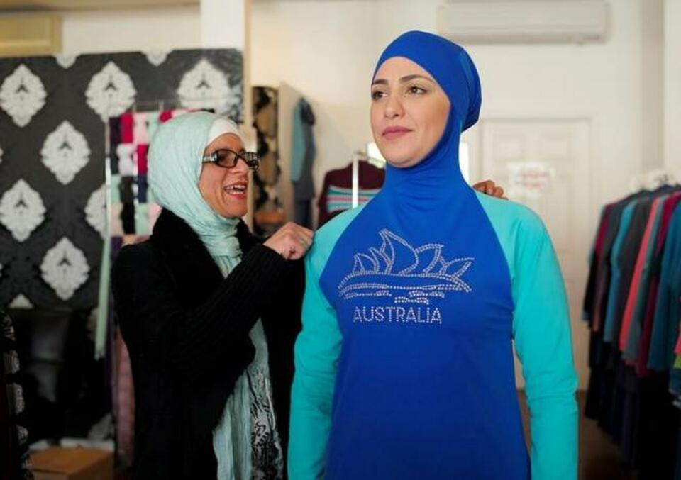 Aheda Zanetti (left), designer of the Burkini swimsuit, adjusts one of the swimsuits on model Salwa Elrashid at her fashion store in Sydney, August 23, 2016. (Reuters Photo/Jason Reed)