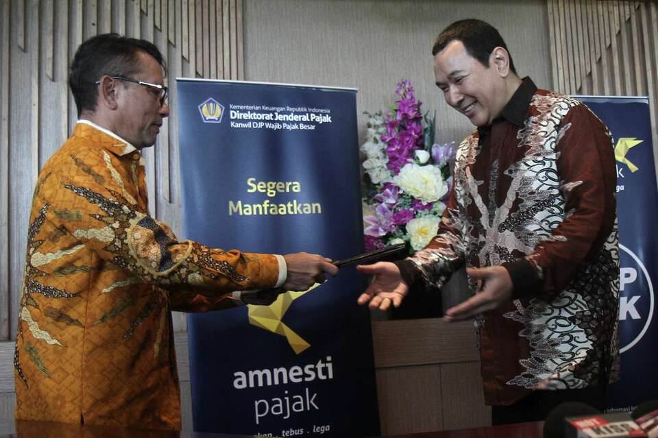 Tommy Suharto, right, hands over his tax report to Ken Dwijugiasteadi, director general for taxation at the Ministry of Finance, in September 2016. (SP Photo/Joanito De Saojoao)