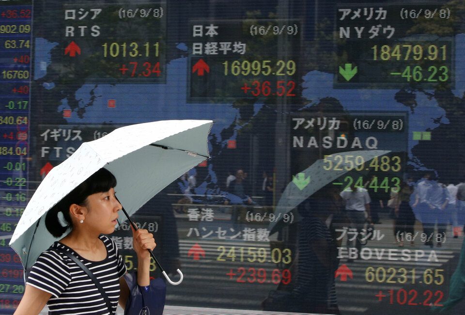 A woman walks past stock quotation board outside a brokerage in Tokyo, Japan, September 9, 2016.   (Reuters Photo/Kim Kyung-Hoon)