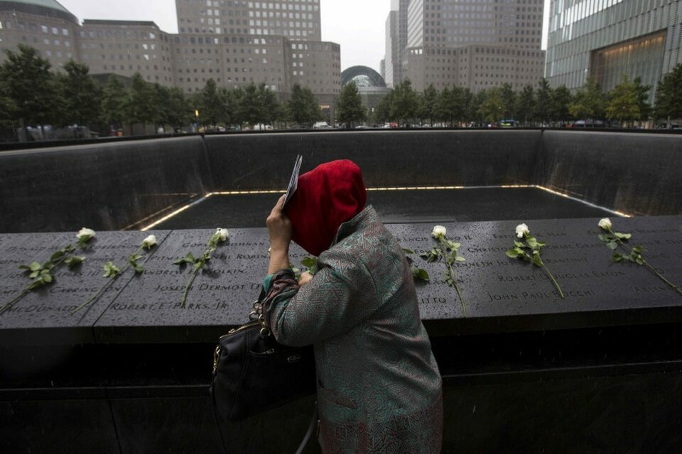 A woman places white roses at the National September 11 Memorial and Museum in Lower Manhattan in New York, September 10, 2015. (Reuters Photo/Andrew Kelly)