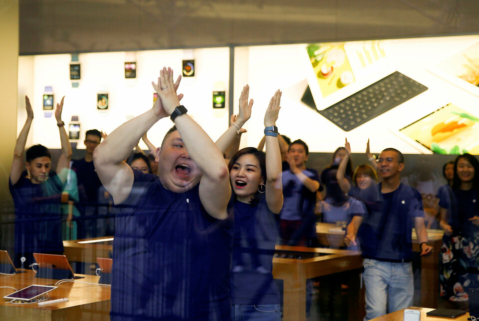 Staff members perform a dance routine before opening an Apple store to customers who line up to purchase the new iPhone 7 in Beijing, China, September 16, 2016. (Reuters Photo/Thomas Peter)