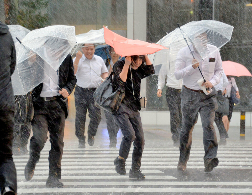 Pedestrians holding umbrellas struggle against strong wind and heavy rains caused by Typhoon Malakas in Nagoya, central Japan.   (Reuters Photo/Kyodo)