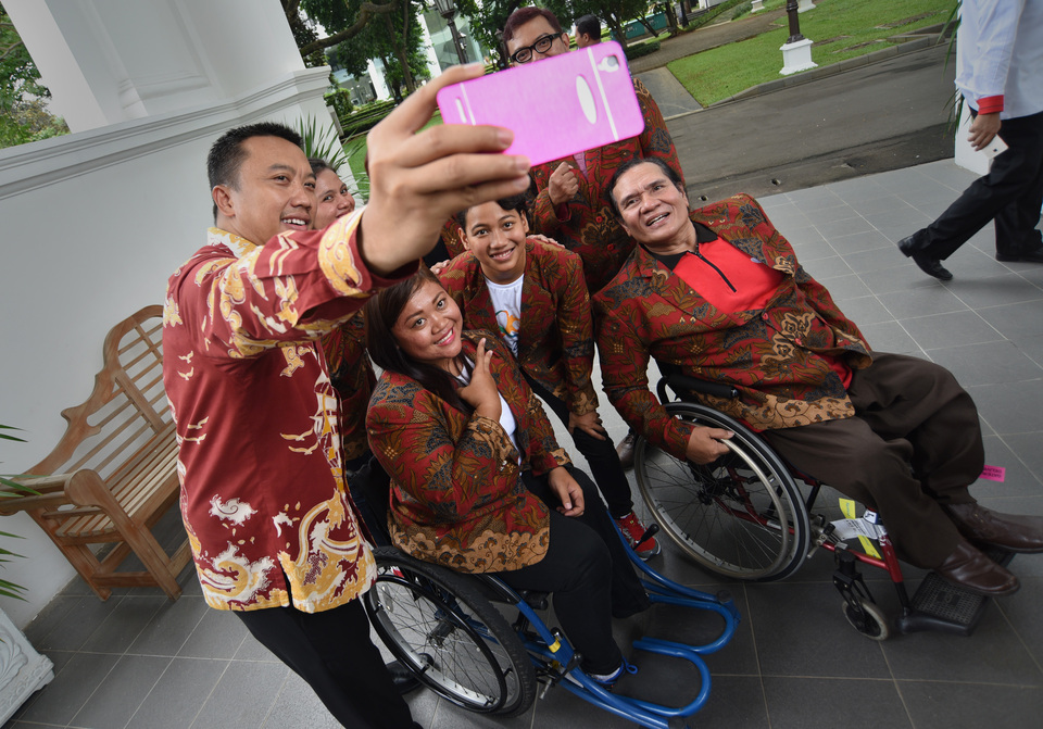 Sports Minister Imam Nahrawi (left) takes a selfie with Paralympic athletes at Presidential Palace, Jakarta, on Thursday (22/09). (Antara Photo/Yudhi Mahatma)