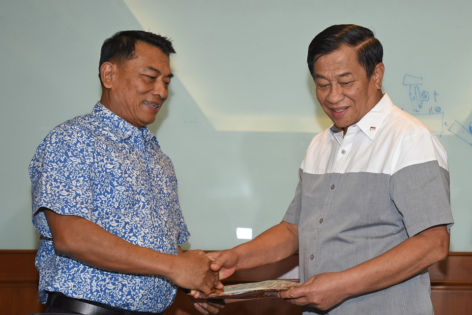 Indonesian Football Association (PSSI) electoral committee head Agum Gumelar, right, shakes hands with one of the verified chairmanship candidates, retired Indonesian Military (TNI) chief Gen. Moeldoko. (Antara Photo/Wahyu Putro A.)