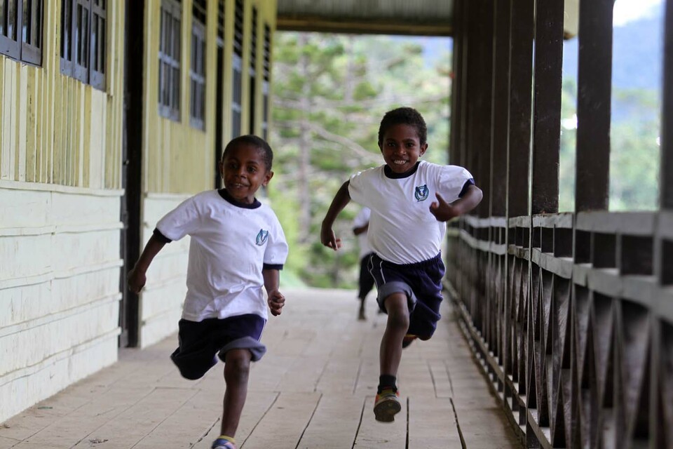 Two boys run and playing after school at Mamit,Village Kembu, Tolikara, Papua. JG Photo/ Donny Andhika