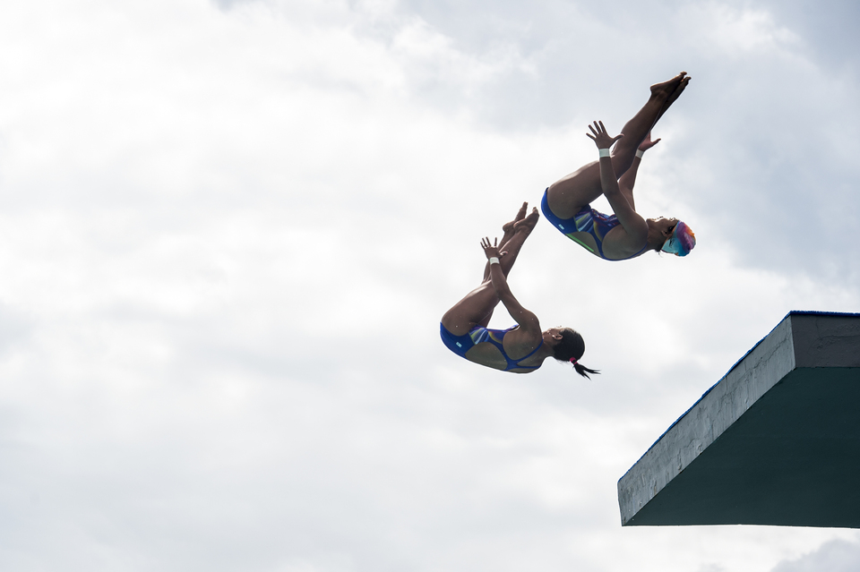 East Java divers Della Dinarsari and Linar Betiliana perform synchronized dives from the tower springboard during the diving finals of the National Sports Week, or PON XIX, in Bandung, West Java, on Sunday (25/09). The pair won gold, followed by the Jakarta side with silver and South Sumatra taking out bronze. (Antara Photo/M Agung Rajasa) 
