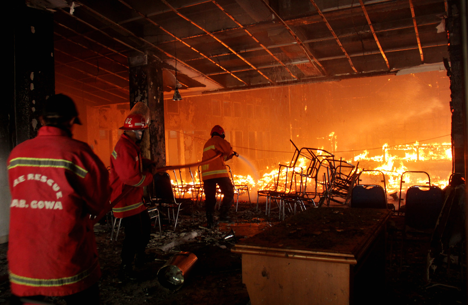Firefighters attend a fire at the local House of Representatives in Gowa, South Sulawesi, on Monday (26/09). The fire destroyed the building and was intentionally set by members of the Concerned Citizens of Gowa group who were protesting Regional Indigenous legislation. (Antara Photo/Abriawan Abhe)

