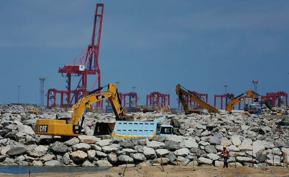 An excavator loads rocks as part of land reclamation on the seafront at the Colombo Port City construction site in Sri Lanka October 4, 2016. (Reuters Photo/Dinuka Liyanawatte)