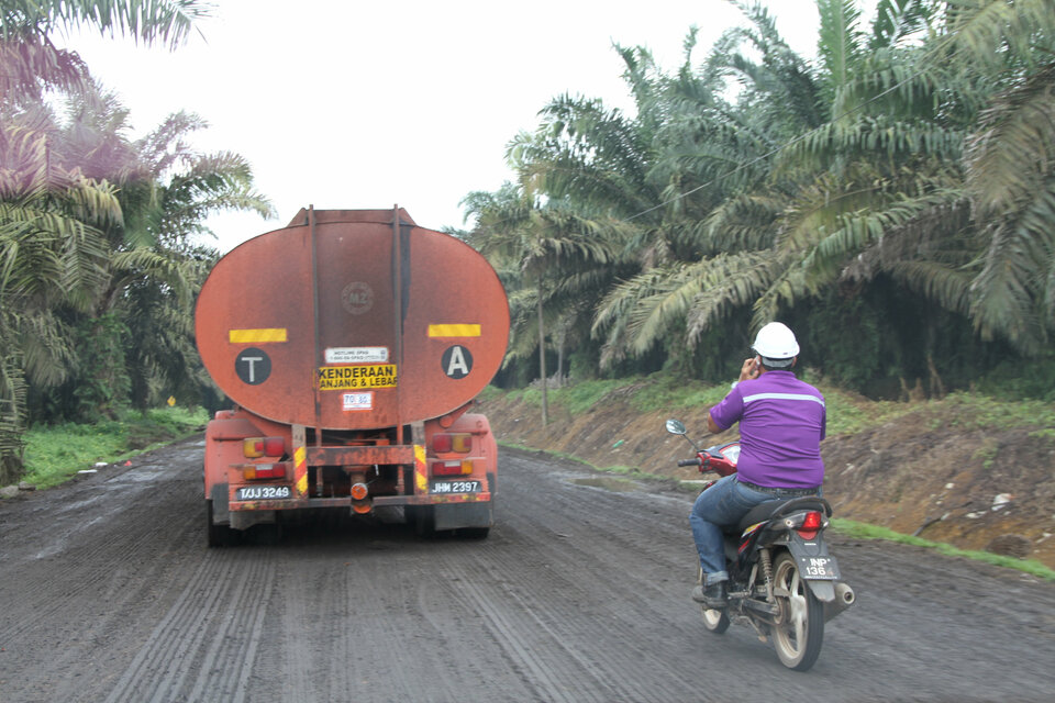 A motorcyclist rides past a palm oil tanker in a plantation in Johor August 24, 2016.     (Reuters Photo/Henning Gloystein)