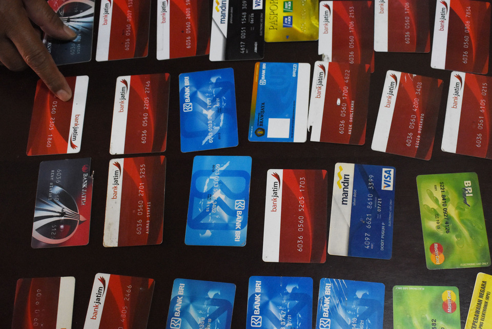 A number of ATM cards are displayed at a press conference in Magetan Police headquarters, East Java, on Monday (17/10) purportedly used in connection with a series of thefts. Police arrested two suspects identified as Junaidi and Hamdani, who are accused of stealing a number of ATM cards in 10 cities across East Java. The duo would use a matchstick and use card modifiers to trap ATM cards at machines. When customers would attempt to withdraw money after keying in their PIN, their ATM cards would get stuck. The suspects would then use the cards to withdraw money once the customer has left. (Antara Photo/ Siswowidodo)