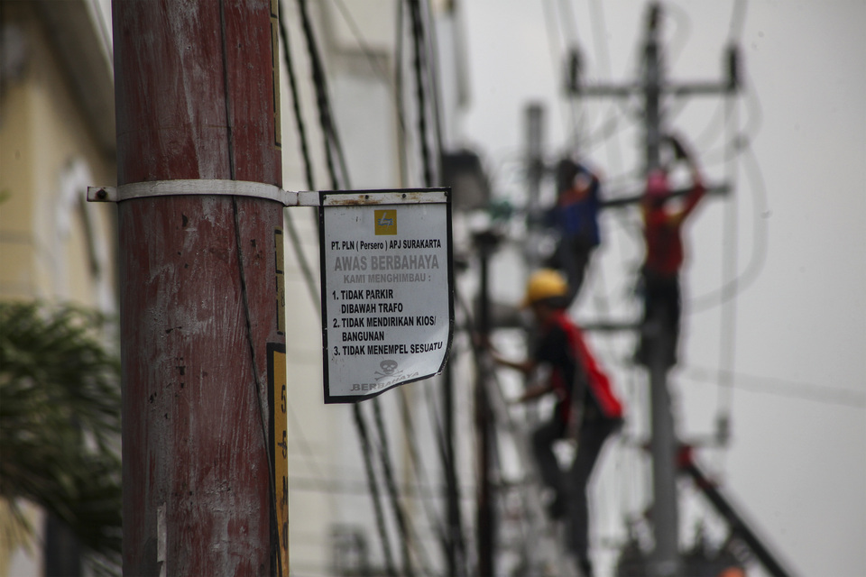 Workers prepare power and telephone poles before the launch of the Walking Street project on Gatot Subroto in Solo, Central Java, on Thursday (06/10). The project, started by the Solo city government, will improve the area making it easier for pedestrians to access the street. (Antara Photo/Maulana Surya)

