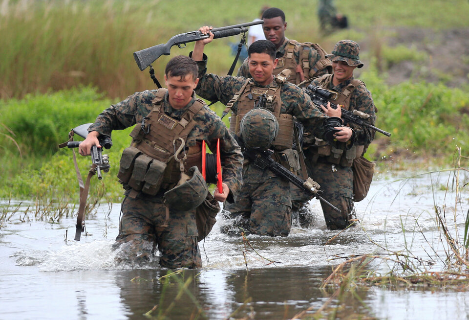 Members of the United States military cross a flooded area near the shore during the annual US-Philippines amphibious landing exercise (Phiblex) at San Antonio in Zambales province on Oct. 7, 2016. (Reuters Photo/Romeo Ranoco)