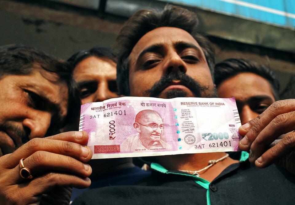 A man displays a new 2000 Indian rupee banknote after withdrawing from a bank in Jammu, November 11, 2016. (Reuters Photo/Mukesh Gupta)