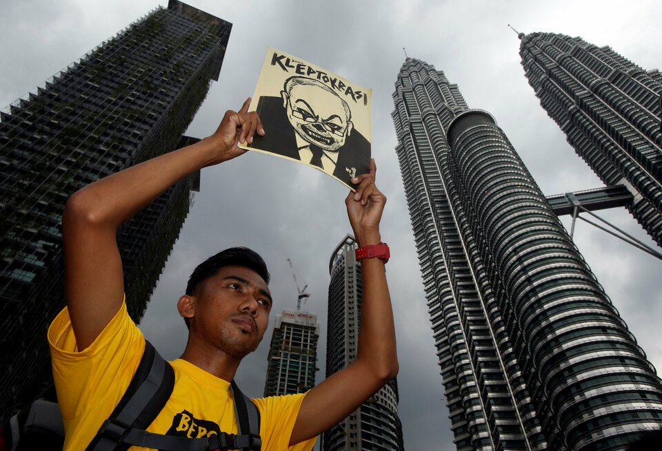 A man holds up a poster as pro-democracy group Bersih stages a 1MDB protest, calling for Malaysian Prime Minister Najib Abdul Razak to resign, in Kuala Lumpur, on Nov. 19. (Reuters Photo/Edgar Su)