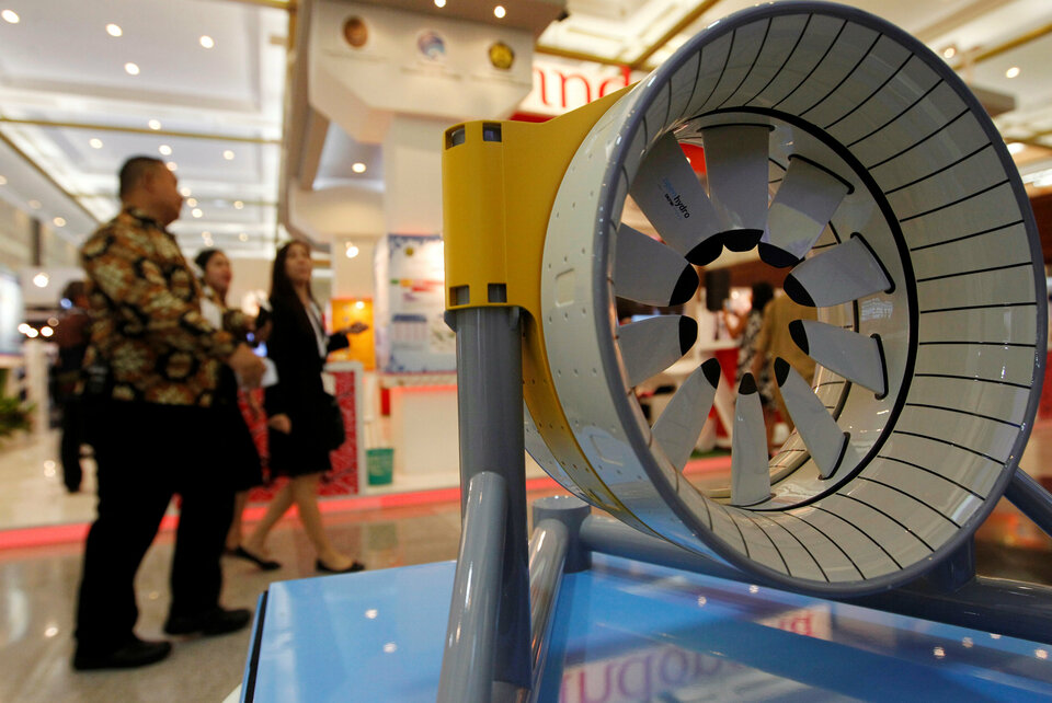 People walk past a model of marine turbine for generating electricity from underwater tidal streams, at an infrastructure expo in Jakarta, Indonesia, November 11, 2016. Picture taken November 11, 2016. (Reuters Photo/Iqro Rinaldi)