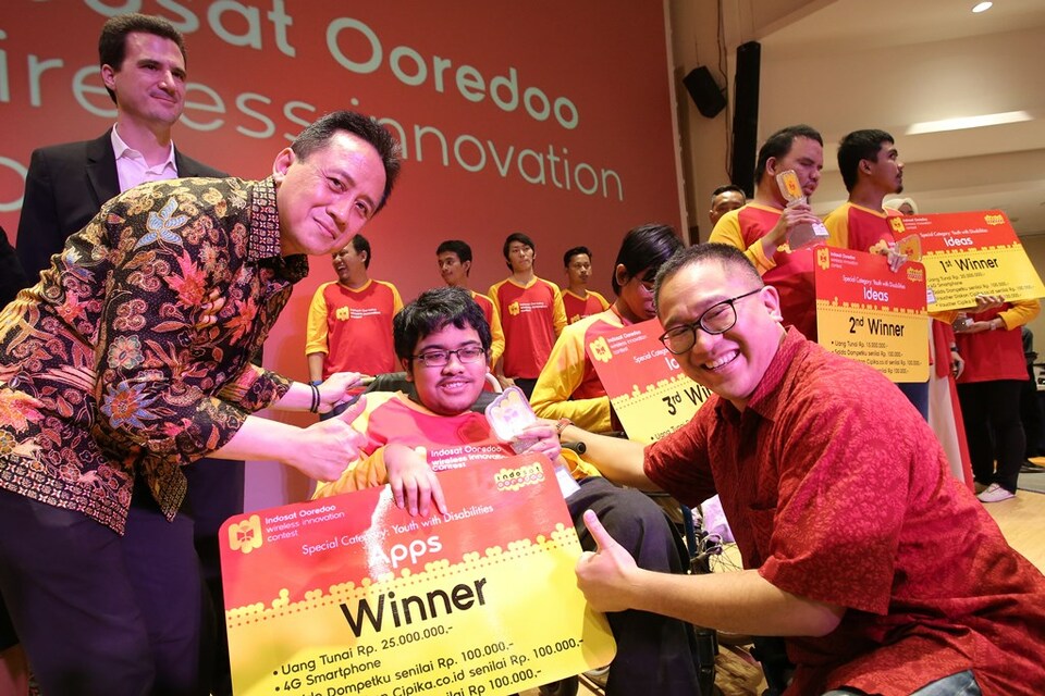 Indosat Ooredoo chief strategy and experience officer Thomas Chevanne, left, Creative Economy Agency head Triawan Munaf, second left, and Indosat Ooredoo president director and chief executive Alexander Rusli present the award to Adrian Naufal who won in the Youth with Disabilities category (02/11). (Photo courtesy of Indosat Ooredoo)