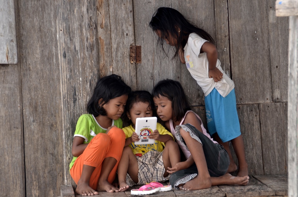 Children in South Mola village, Wakatobi, Southeast Sulawesi, play with a tablet on Monday (07/11). A lack of awareness among parents of the importance of education means around 80 percent of children in the area do not currently attend school, although the facilities have been provided. (Antara Photo/Dewi Fajriani)

