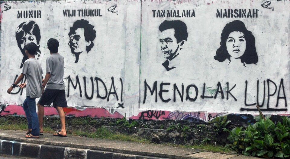 Teenagers pass by a mural displaying prominent Indonesian activists in Jalan Veteran, Bogor city, West Java, on Monday (14/11). 'Never forget' is written under the portraits of slain human rights defender Munir Said Thalib, poet and activist Wiji Thukul — who has been missing since 1998 — national hero Tan Malaka, and labor activist Marsinah, who was kidnapped and murdered in 1993. (Antara Photo/Arif Firmansyah)