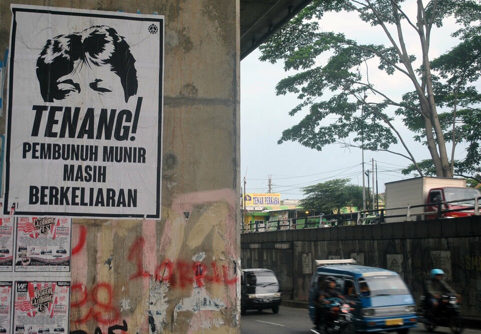 'Beware! Mastermind of Munir's murder is still out there!' says a poster under an overpass in Bogor, West Java. (Antara Photo/Arif Firmansyah)

