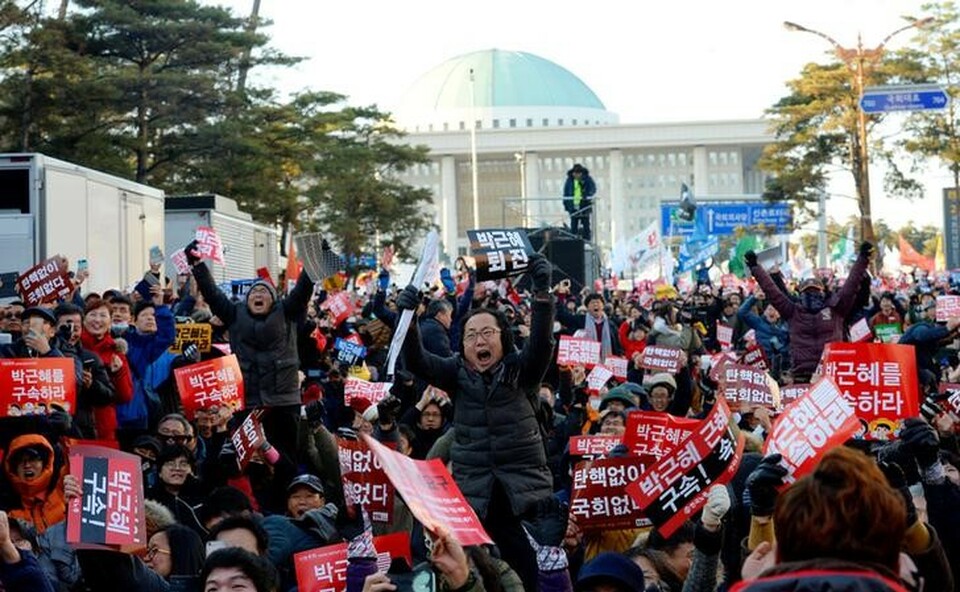People rally after impeachment vote on South Korean President Park Geun-hye was passed, in front of the National Assembly in Seoul, on Friday (09/12). The banners read "Impeach Park Geun-hye."  (Reuters Photo/News1)