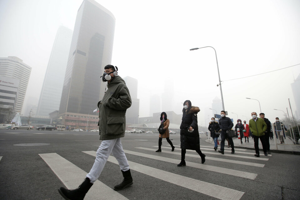 A man wearing a respiratory protection mask walks toward an office building during the smog after a red alert was issued for heavy air pollution in Beijing's central business district, China, December 21, 2016. (Reuters Photo/Jason Lee)