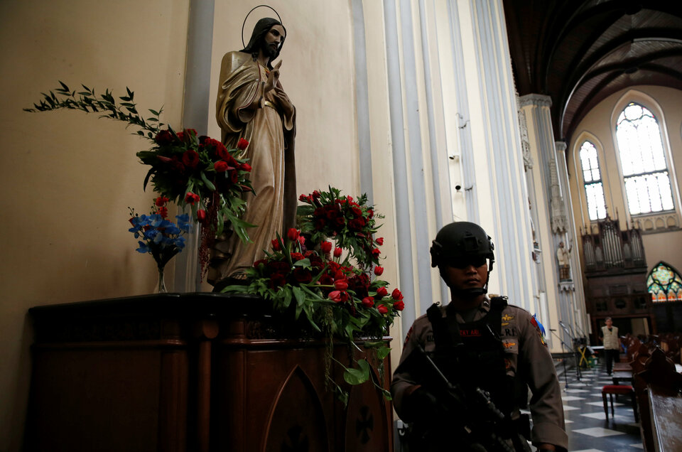 A police officer sweeps the Jakarta Cathedral on Saturday (24/12) ahead of Christmas celebrations. (Reuters Photo/Beawiharta)