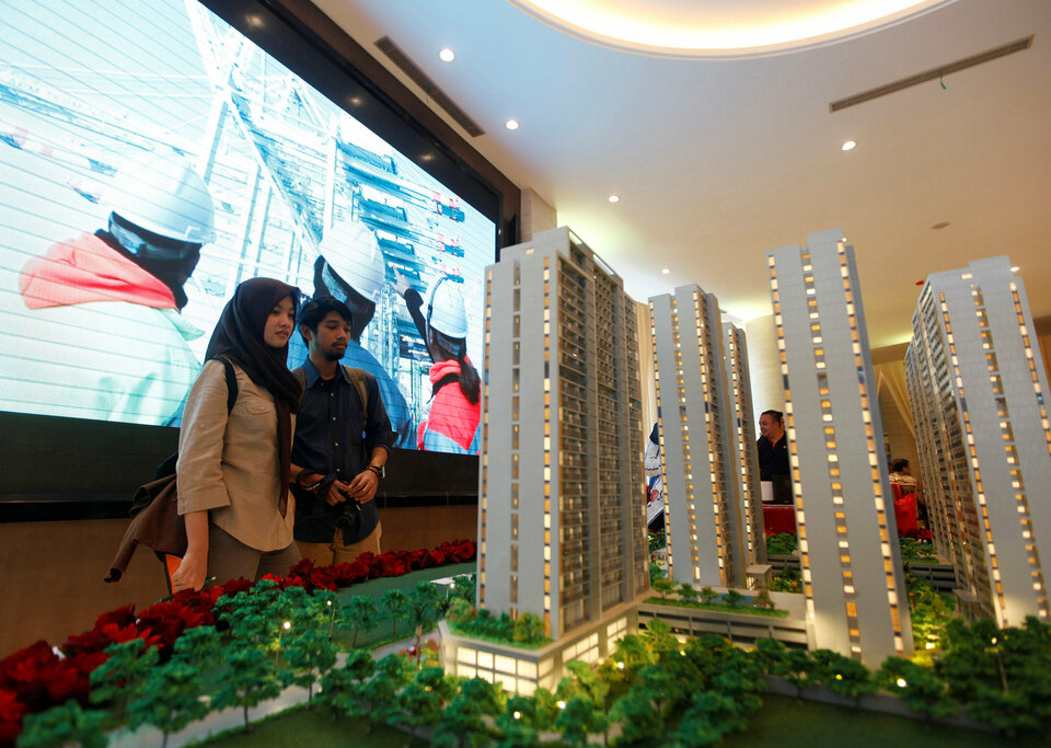 Visitors look at a model of Daan Mogot City apartments, a residential project planned by a unit of China Communication Construction Group (CCCG), in West Jakarta, Indonesia December 10, 2016. (Reuters Photo/Fatima El-Kareem)